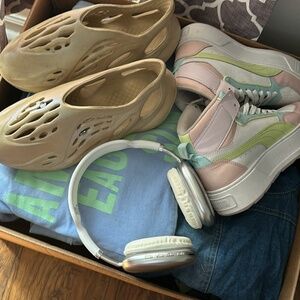 Bucket of clothes shoes and headphones